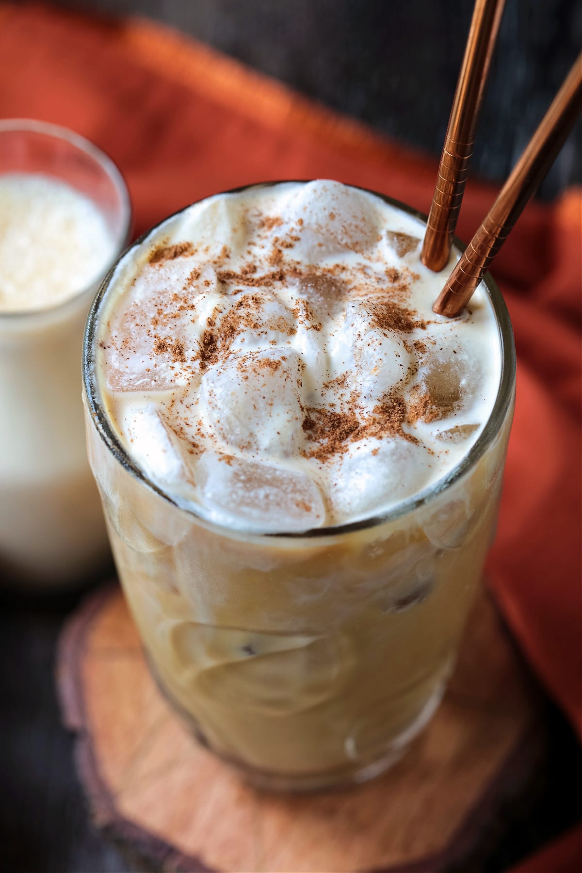 pumpkin cream cold brew in glass with spice on top and straws