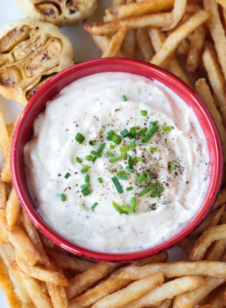 garlic aioli in a red bowl with french fries