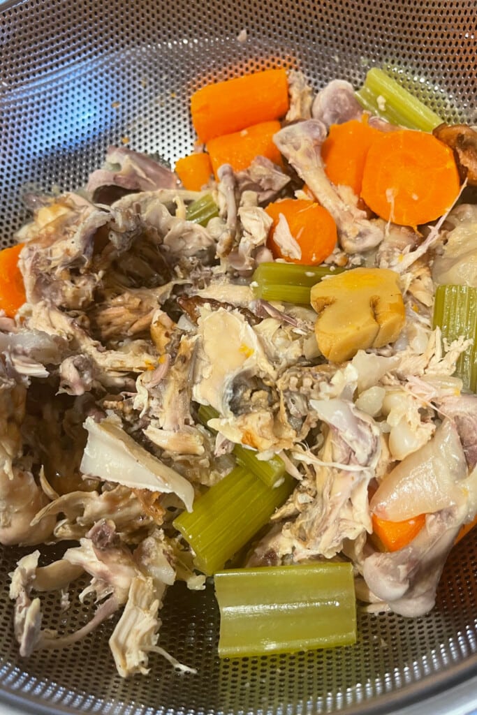strained chicken bones and vegetables from making stock
