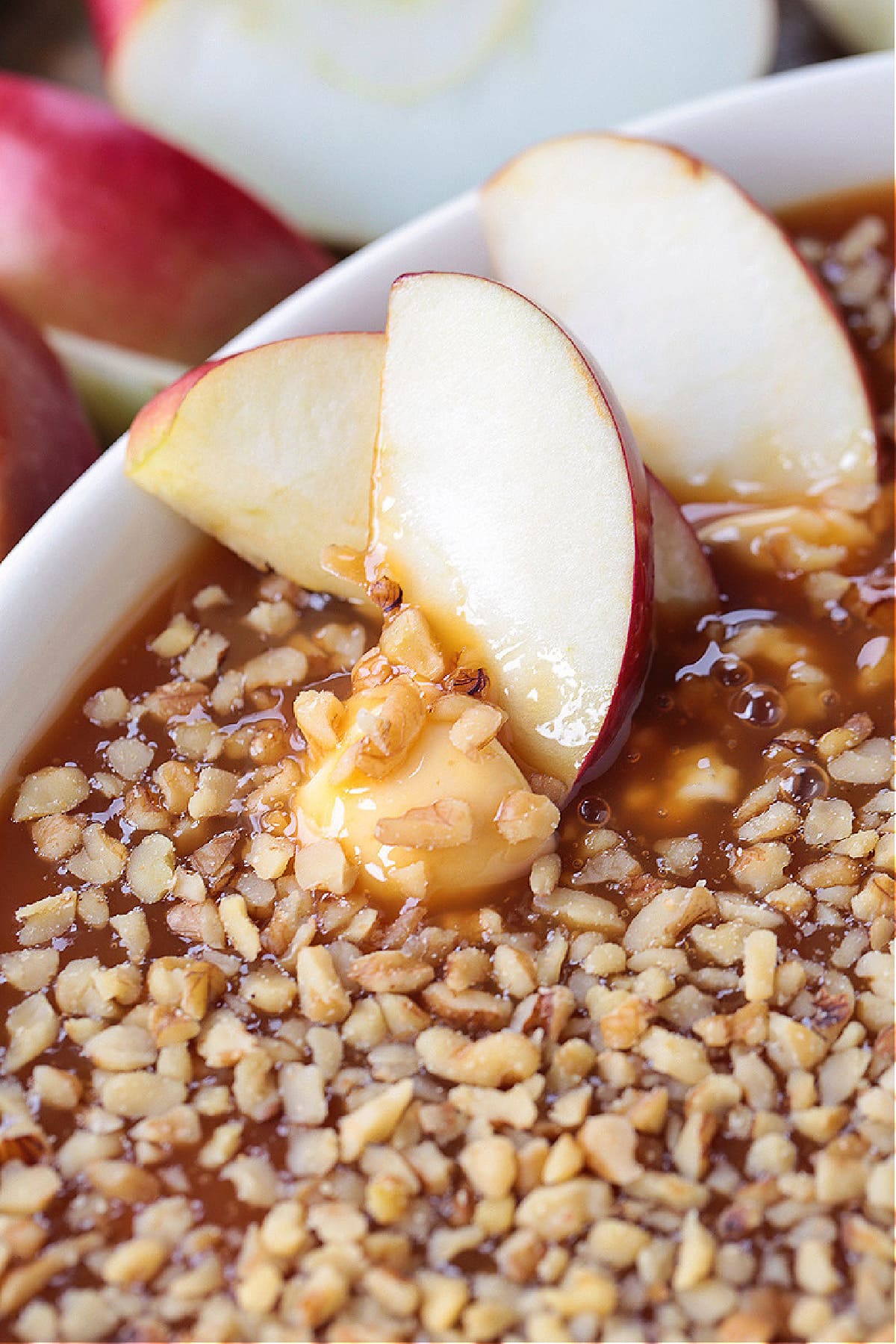 This Caramel Apple Dip is perfect for parties! An easy dessert recipe with the flavors of a nutty caramel apple and sweetened cream cheese. apple slices dipped in caramel apple dip