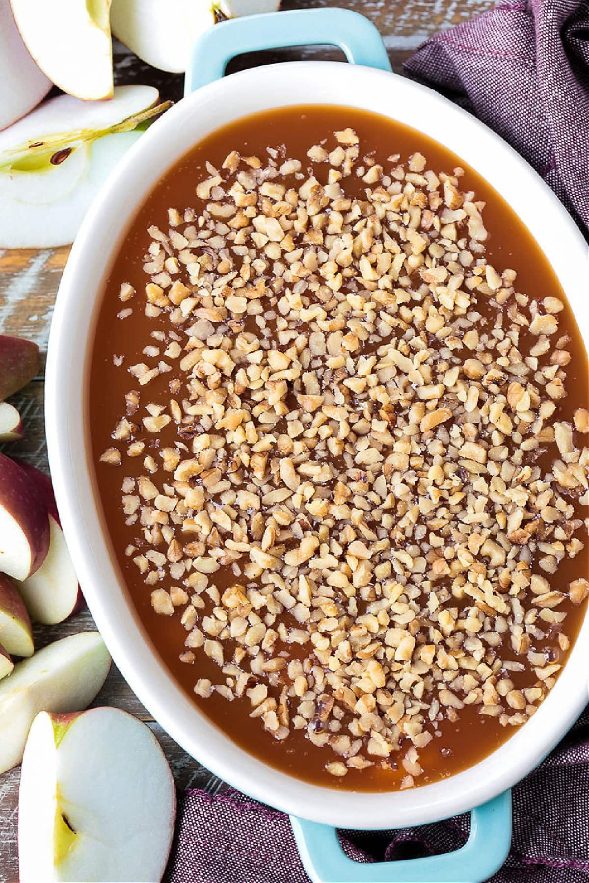 This Caramel Apple Dip is perfect for parties! An easy dessert recipe with the flavors of a nutty caramel apple and sweetened cream cheese. caramel apple dip with chopped walnuts on top