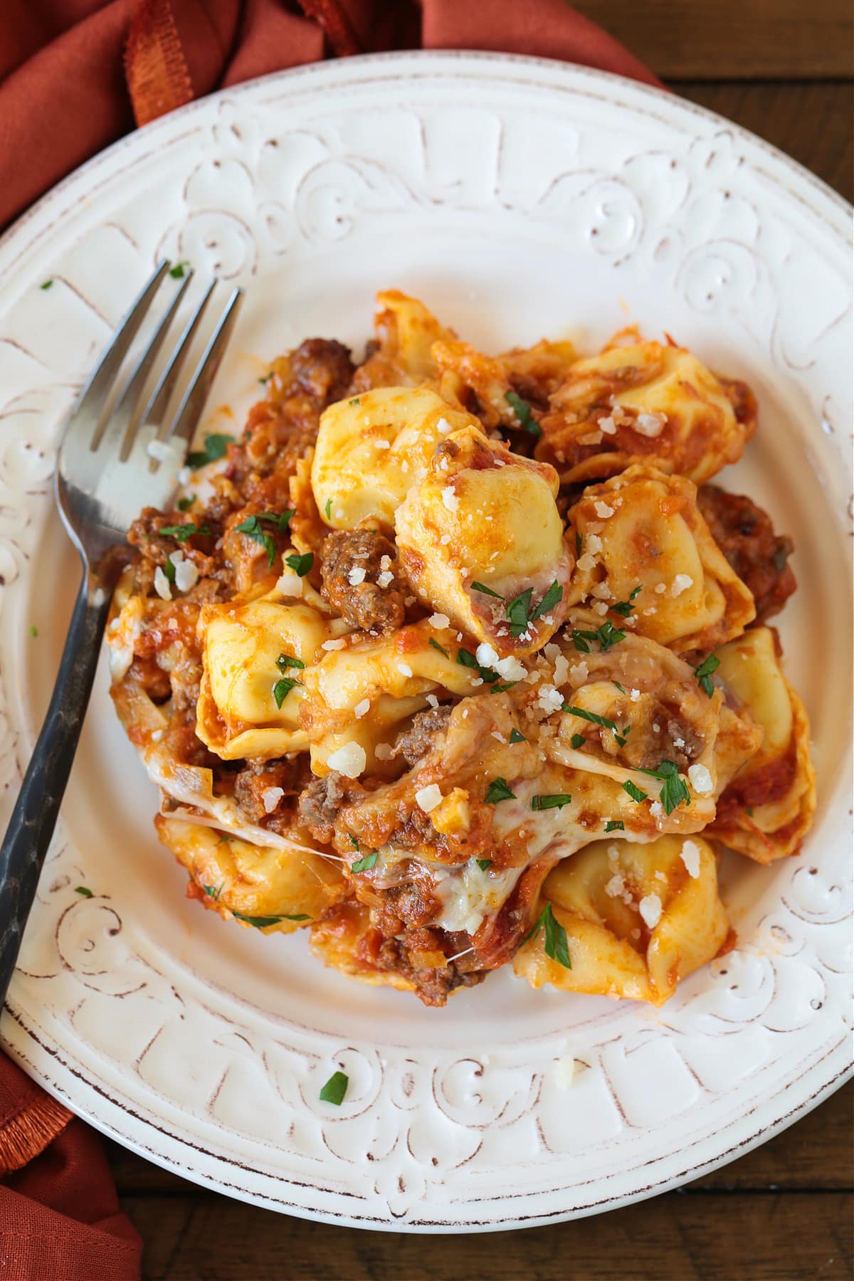 cheesy tortellini bake on a white plate with fork