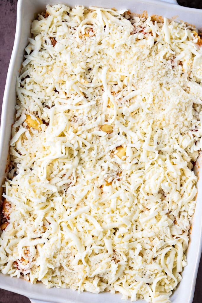 Make this Cheesy Tortellini Bake for an easy weeknight dinner or a cozy meal for guests. A hearty pasta casserole that everyone will love! mozzarella cheese on top of a pasta casserole