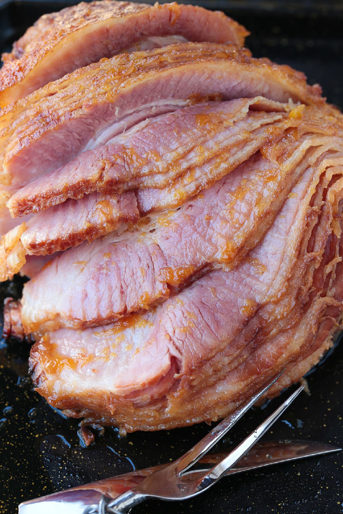 Sliced ham with glaze and a serving fork