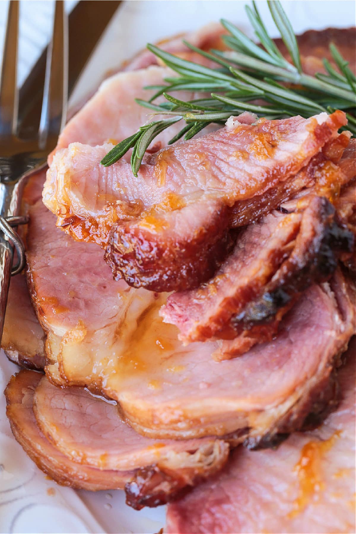 spiral sliced ham on serving platter with rosemary