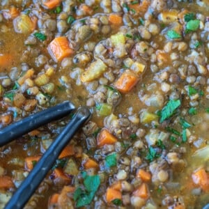 spoons in a bowl of lentil soup