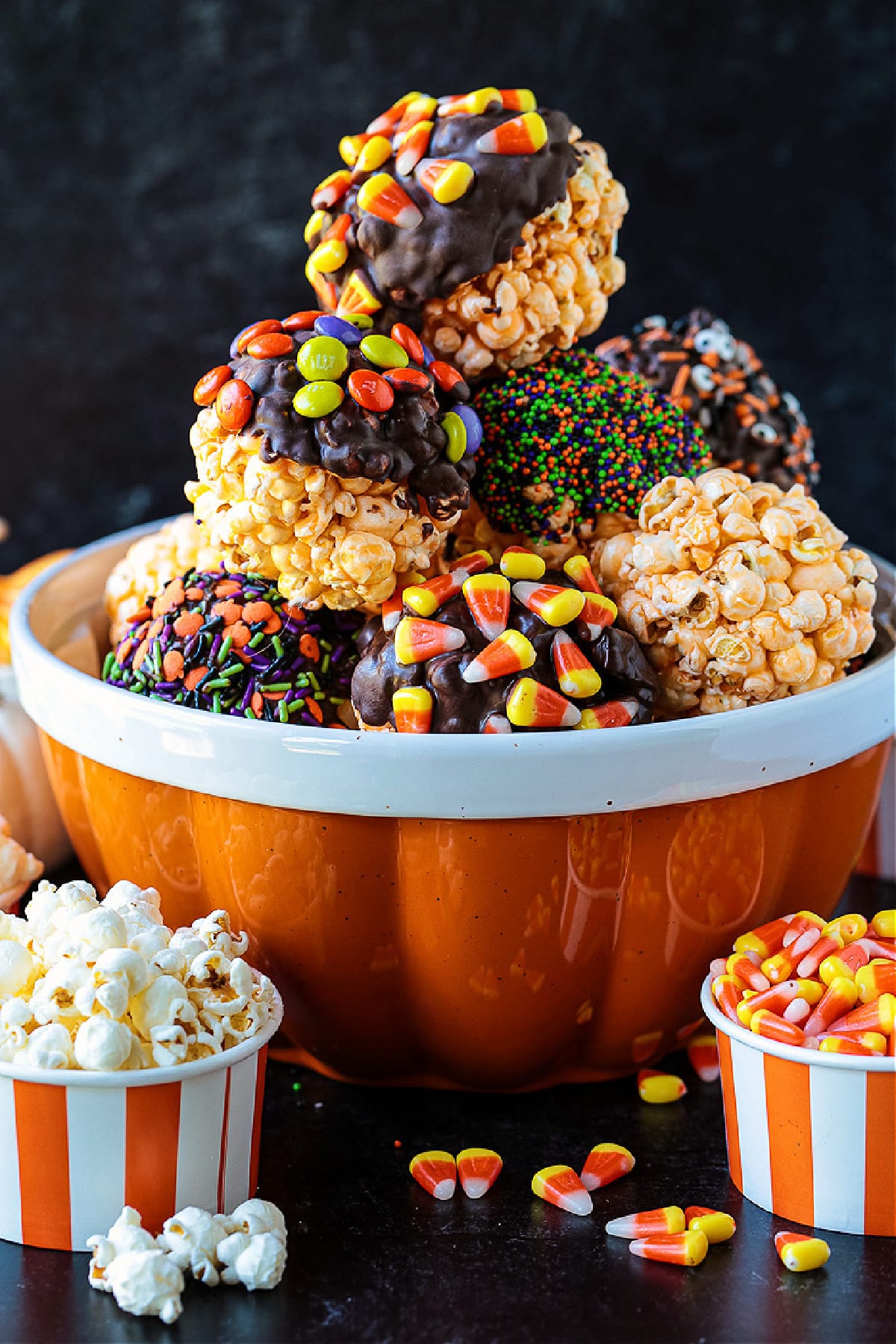 Halloween Popcorn Balls are a tasty and festive homemade treat for Halloween! Perfect for trick-or-treaters or for a Halloween party favor! popcorn ball decorated in Halloween candy