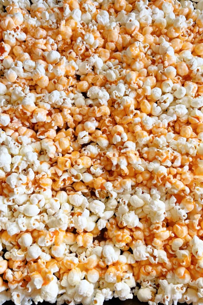 Halloween Popcorn Balls are a tasty and festive homemade treat for Halloween! Perfect for trick-or-treaters or for a Halloween party favor! orange colored popcorn for popcorn balls