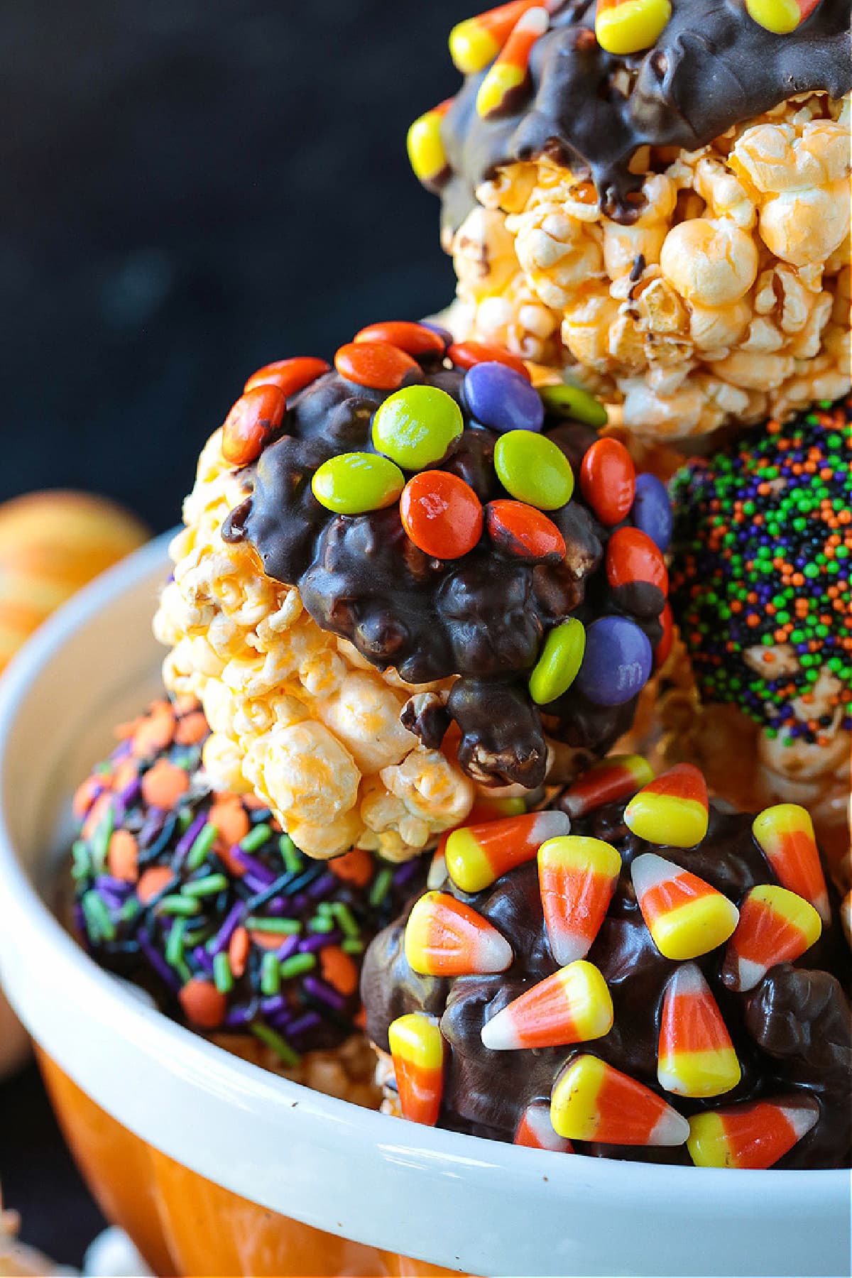Halloween Popcorn Balls are a tasty and festive homemade treat for Halloween! Perfect for trick-or-treaters or for a Halloween party favor! popcorn balls with chocolate and M&M's