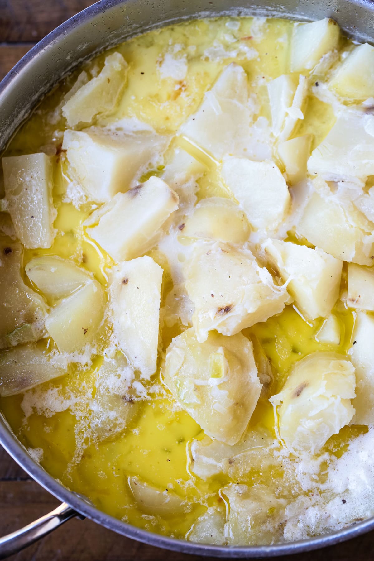 diced potatoes in a pot with chicken broth and butter