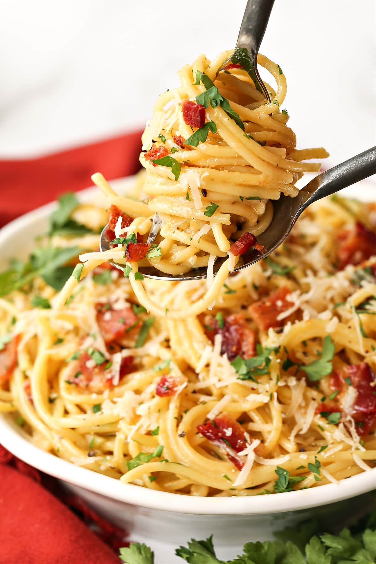 Enjoy the deliciousness of this simple Pasta Carbonara any time of the week! A 15 minute pasta dish that's oozing with comfort food feels. pasta carbonara twirled on a fork and spoon