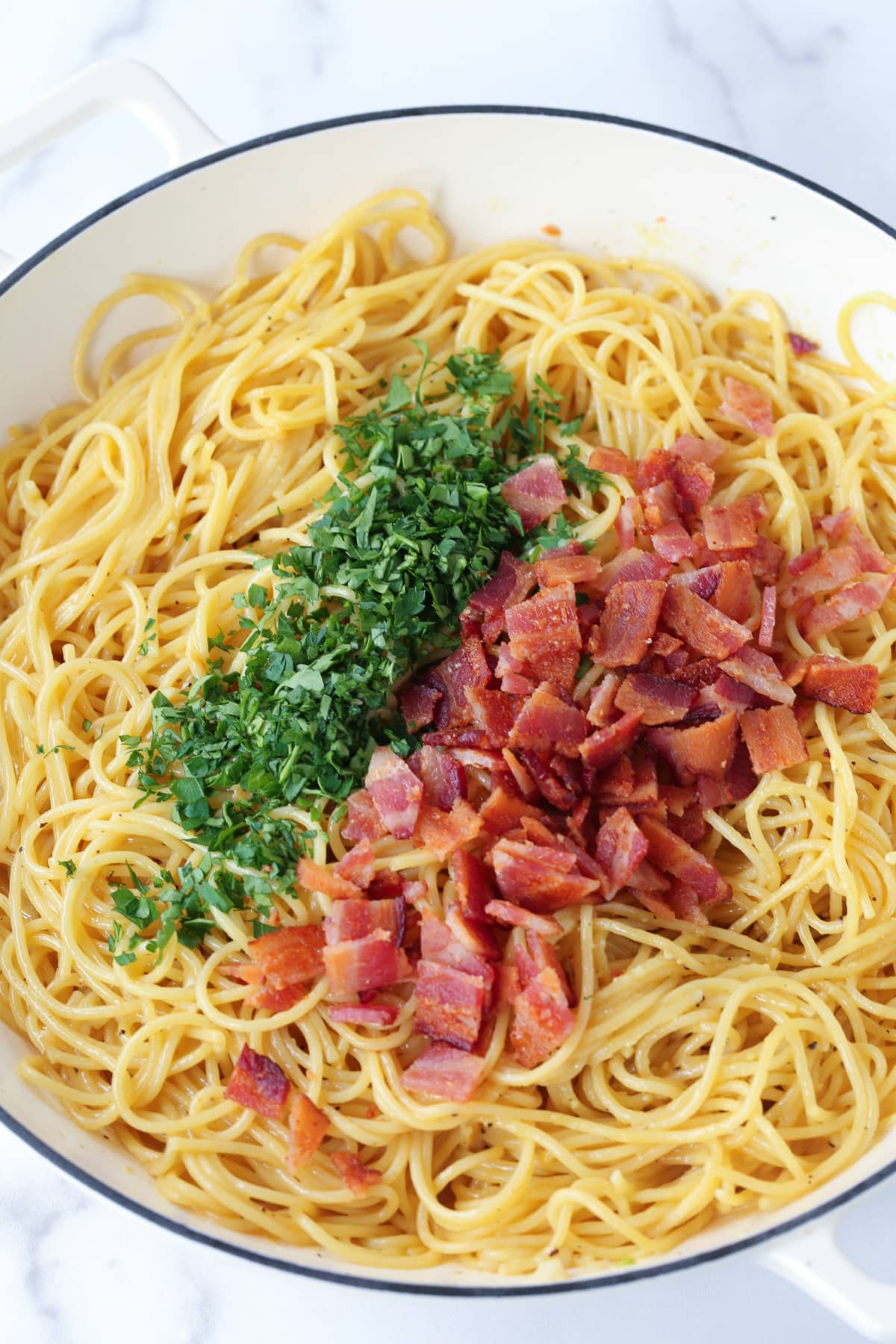 Enjoy the deliciousness of this simple Pasta Carbonara any time of the week! A 15 minute pasta dish that's oozing with comfort food feels. spaghetti in pot with bacon and parsley