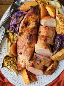 pork tenderloins on a bed of apples and cabbage