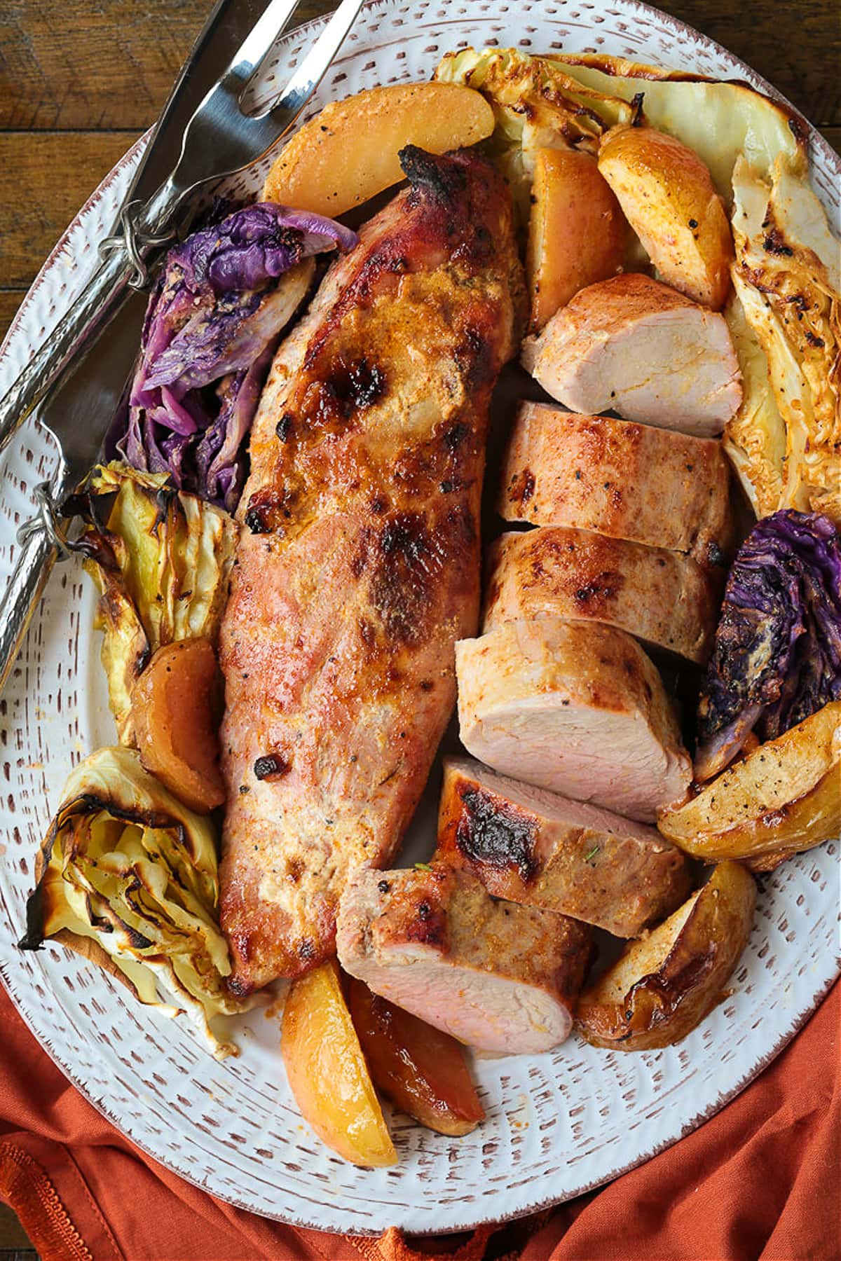 pork tenderloins on a bed of apples and cabbage