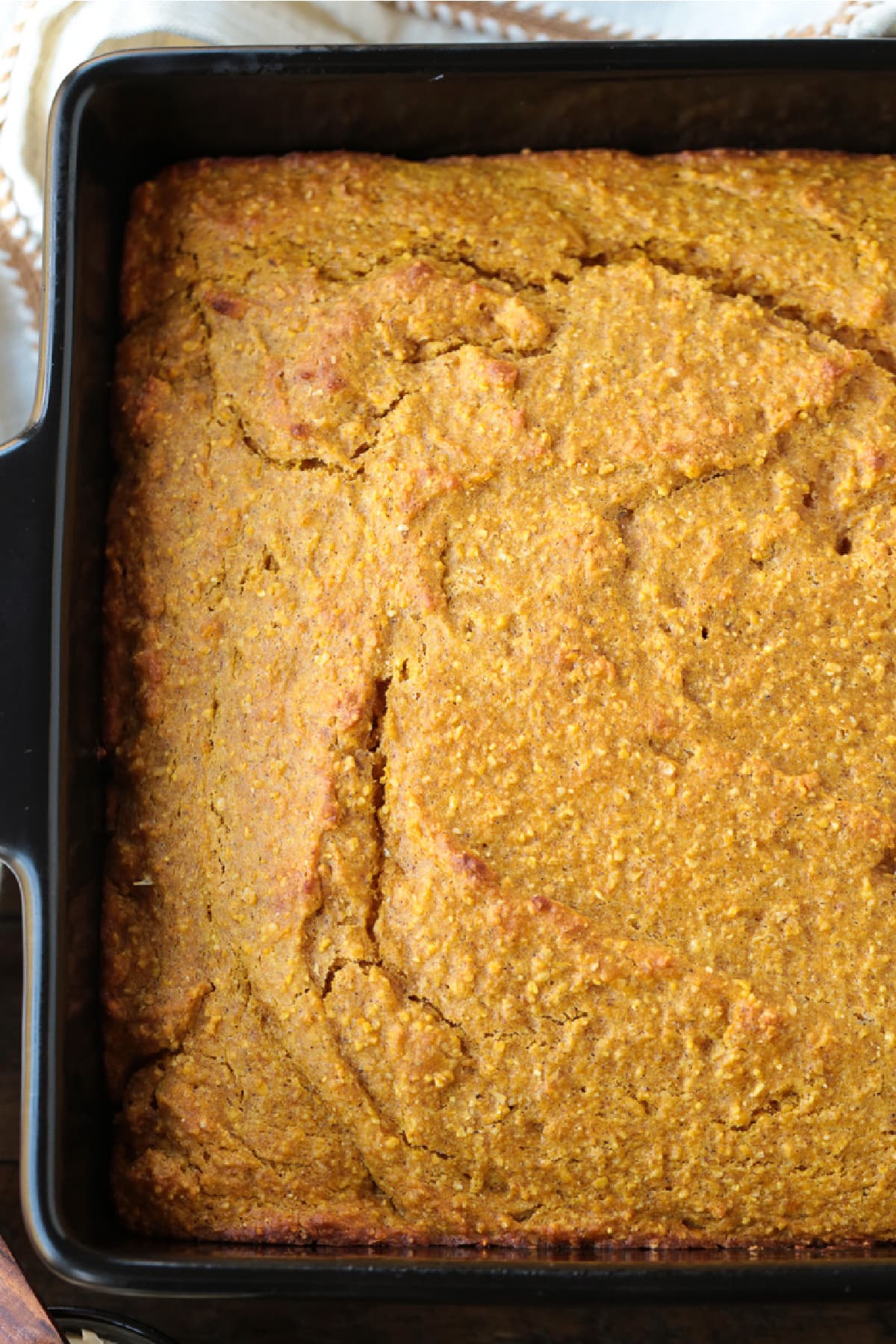 This Pumpkin Cornbread is giving all the fall vibes! Insanely moist and flavorful, with the perfect amount of pumpkin spice flavor! cornbread recipe flavored with pumpkin in baking dish