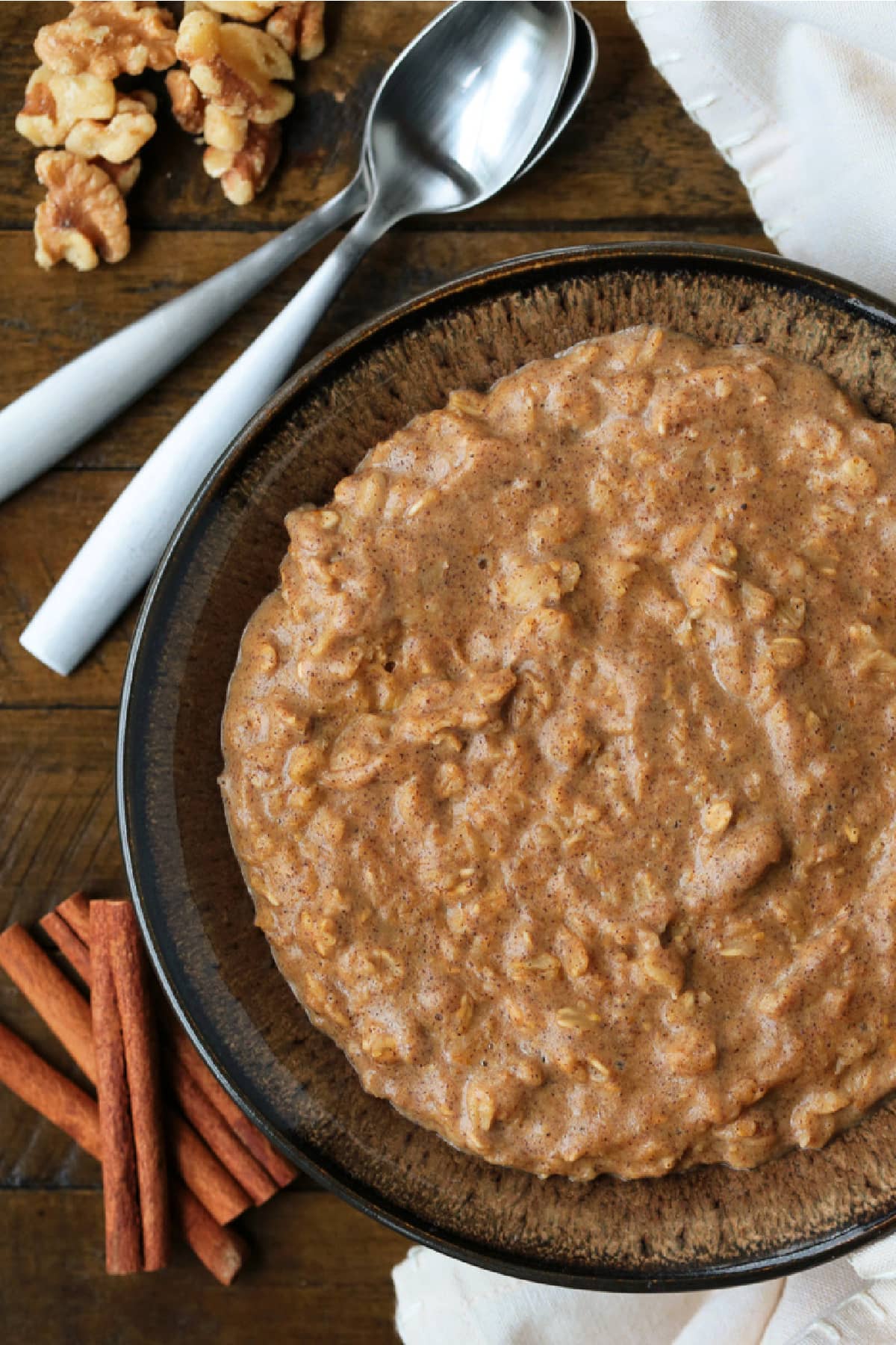 Pumpkin Oatmeal is so hearty and comforting, and only takes 10 minutes to make! A cozy, healthy breakfast with all your favorite fall flavors! pumpkin oatmeal in a brown bowl with spoons
