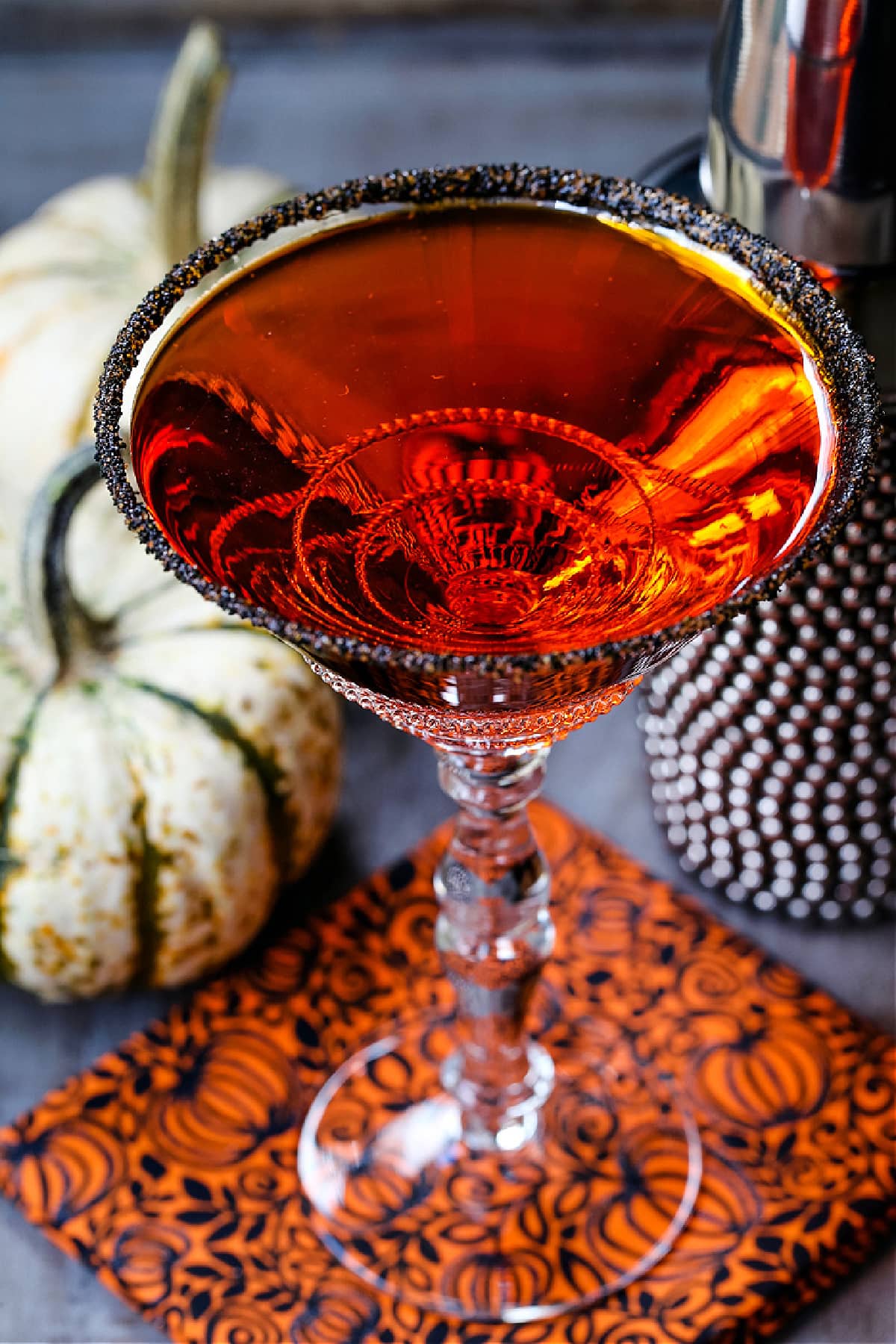 a pumpkin martini with a black and orange sugar rim