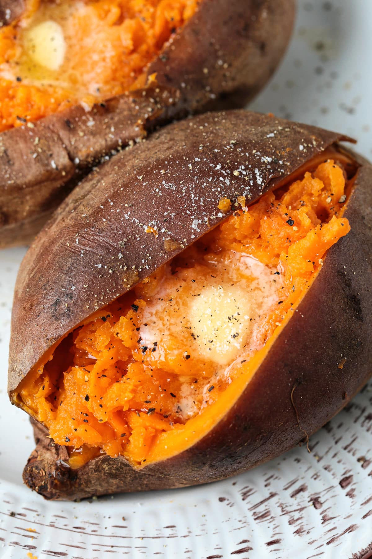 sweet potato cut open with butter, salt and pepper