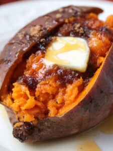 cooked sweet potato split open with butter, brown sugar and honey