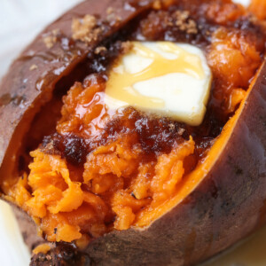cooked sweet potato split open with butter, brown sugar and honey