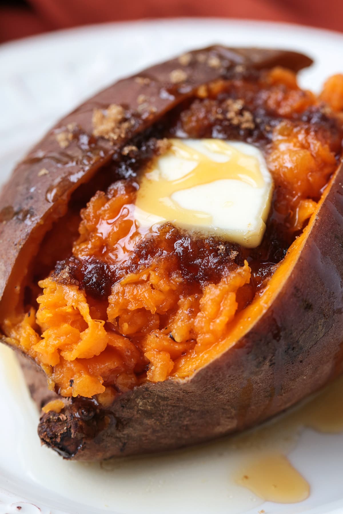 cooked sweet potato split open with butter, brown sugar and honey