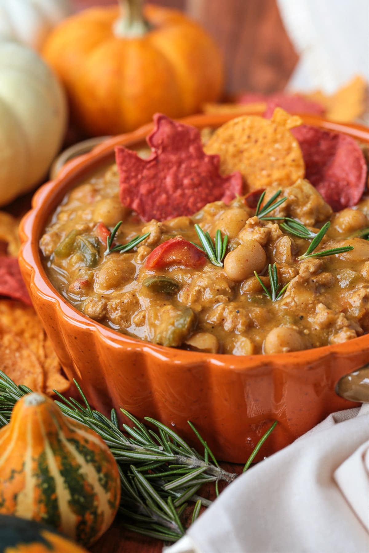 This cozy Pumpkin Chili recipe is giving all the fall vibes! A creamy, hearty turkey chili simmered with pumpkin puree, white wine and beans! Turkey chili with pumpkin in a bowl with napkin