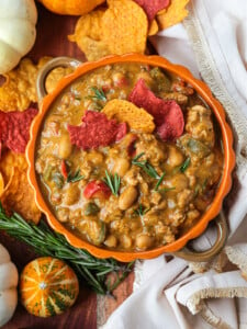 Turkey chili in an orange bowl with pumpkin around