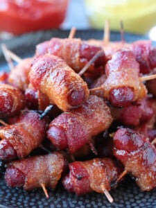 bacon wrapped smokies on plate with ketchup and mustard