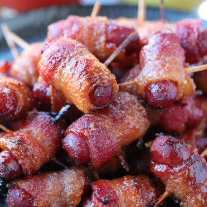 bacon wrapped smokies on plate with ketchup and mustard