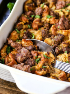 sausage stuffing in baking dish with serving spoon