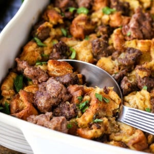 sausage stuffing in baking dish with serving spoon