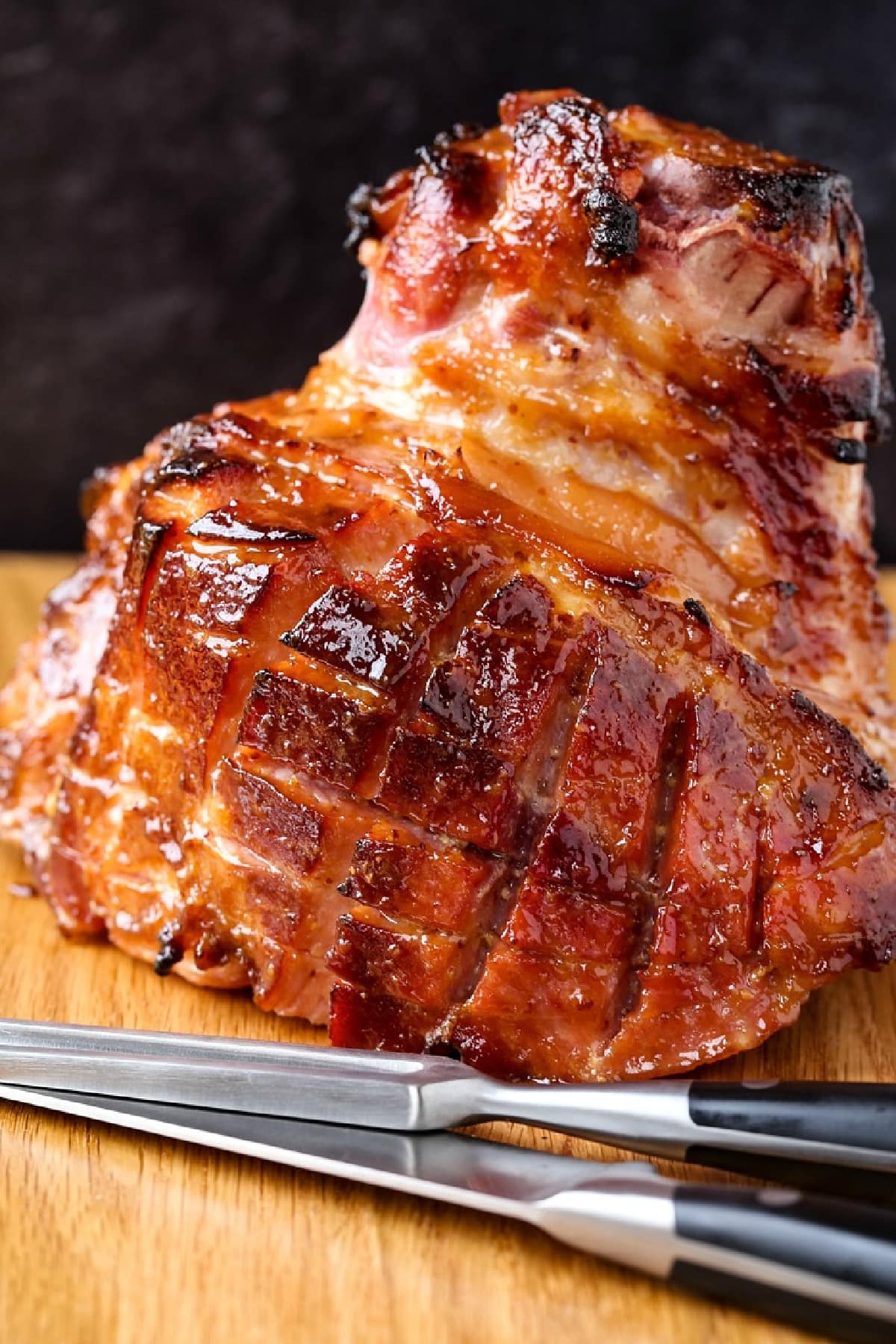 baked ham resting on board with carving knife