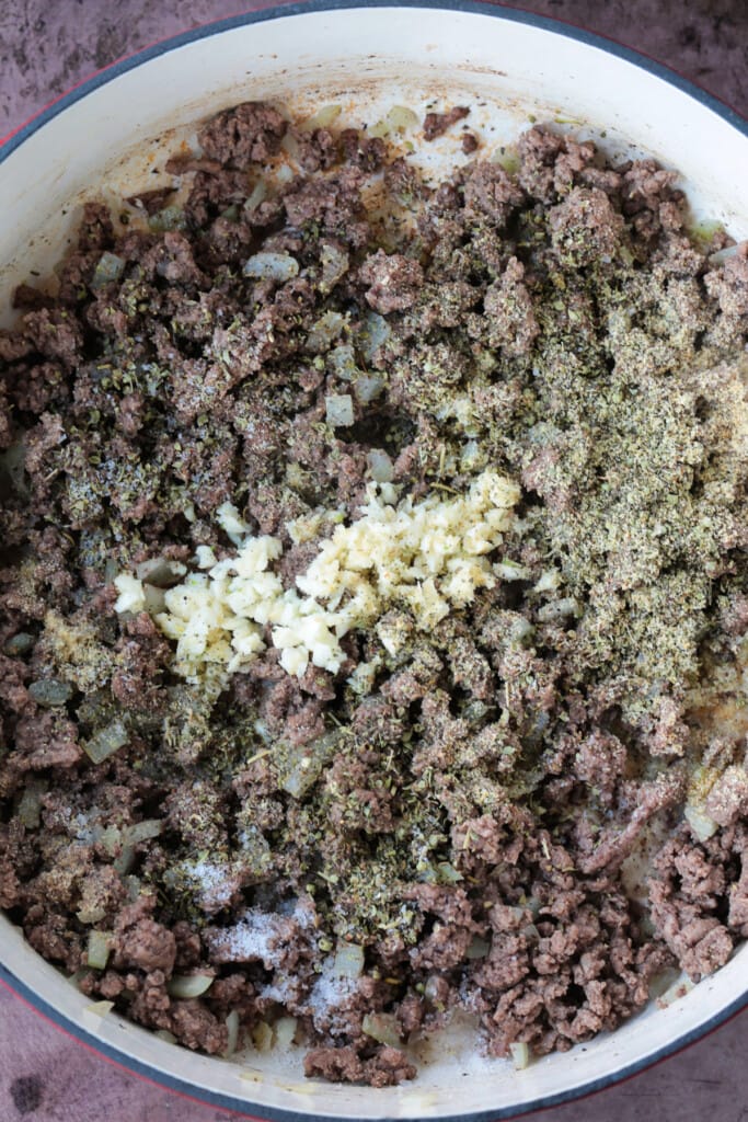 This Deconstructed Lasagna recipe is so much easier than making a traditional lasagna! All the same flavors you love, ready in 30 minutes. browned ground beef in pot with garlic