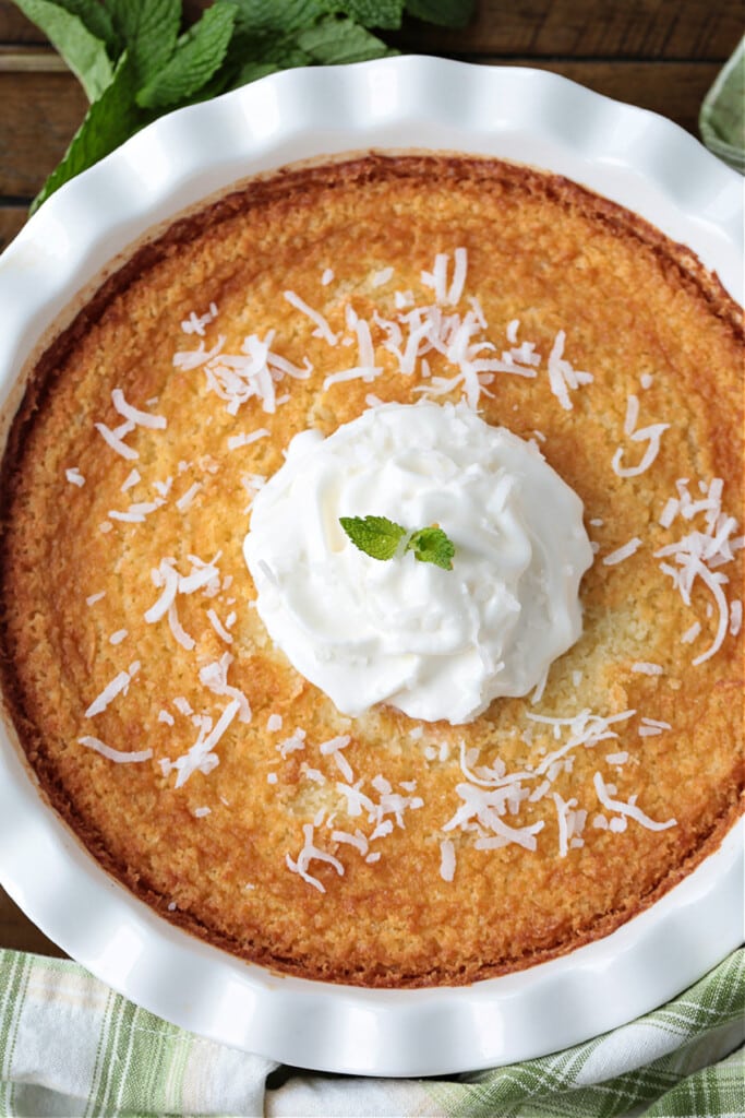 Impossible Coconut Pie is so easy to make it seems impossible! A creamy, sweet, custard pie that forms it's own crust as it bakes! impossible coconut pie with whipped cream and mint