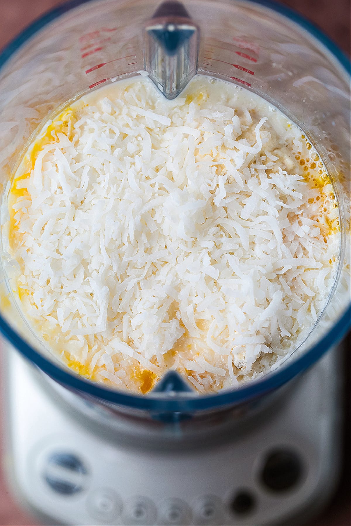 Impossible Coconut Pie is so easy to make it seems impossible! A creamy, sweet, custard pie that forms it's own crust as it bakes! blender with coconut pie filling and shredded coconut
