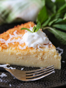 slice of coconut pie on black plate with fork