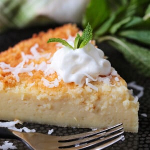 slice of coconut pie on black plate with fork