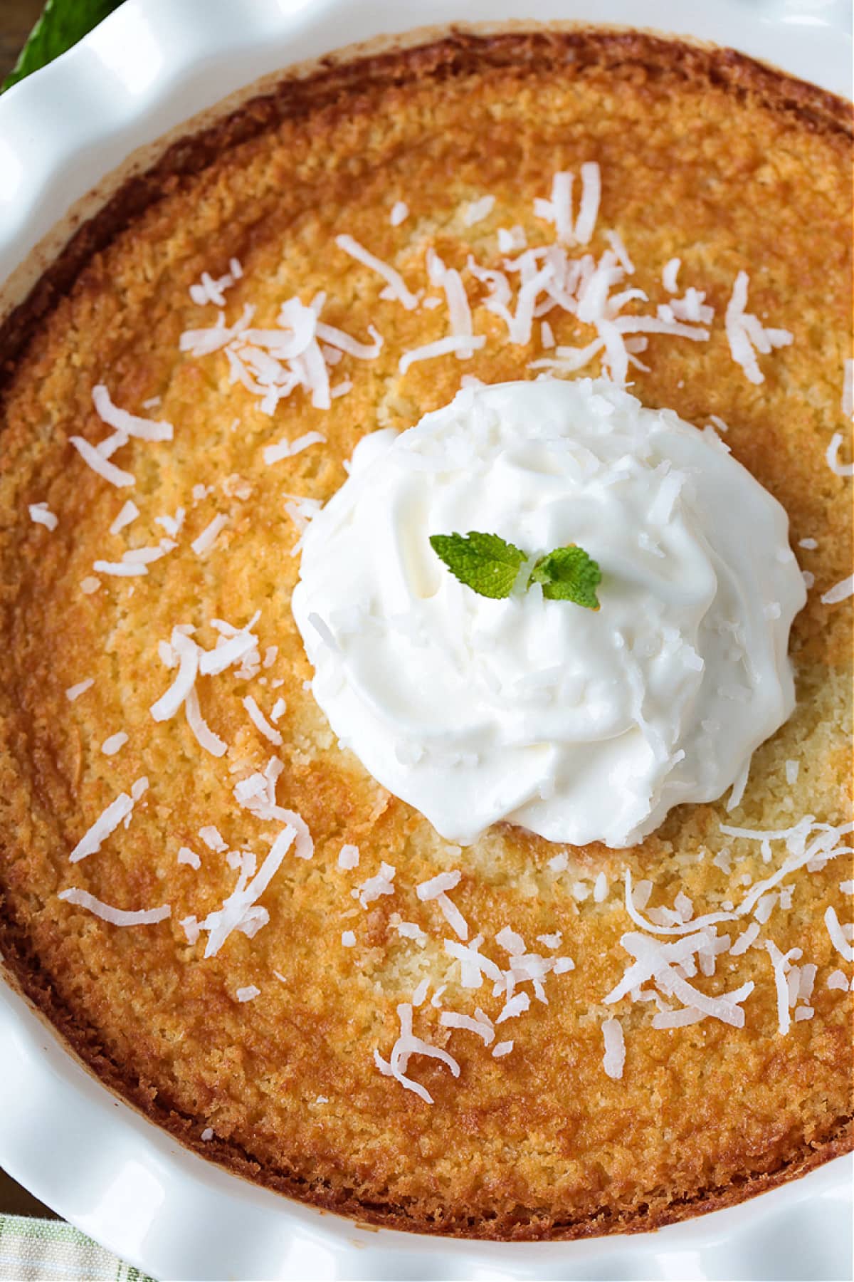 Impossible Coconut Pie is so easy to make it seems impossible! A creamy, sweet, custard pie that forms it's own crust as it bakes! coconut pie with whipped cream and mint