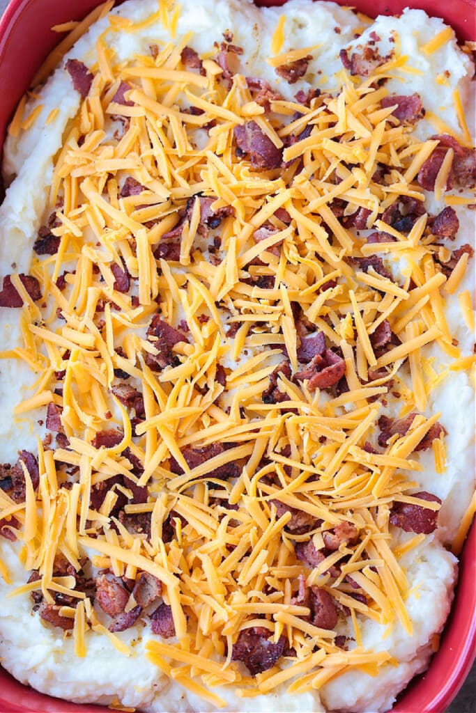 This Loaded Mashed Potato Casserole is so hearty and delicious. A make ahead potato side dish that makes party planning and holidays so easy! mashed potato casserole with bacon and cheddar cheese