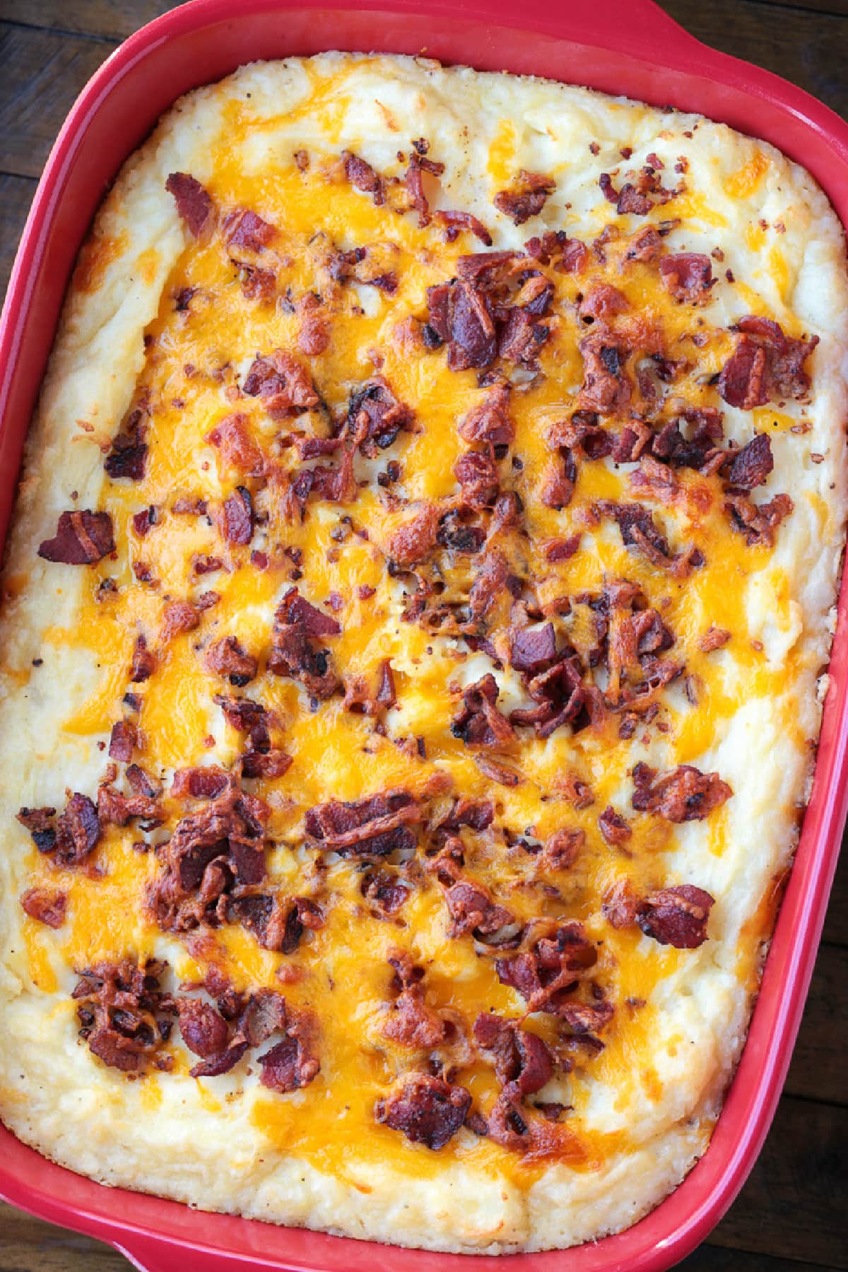 This Loaded Mashed Potato Casserole is so hearty and delicious. A make ahead potato side dish that makes party planning and holidays so easy! mashed potato casserole with bacon and cheese on top