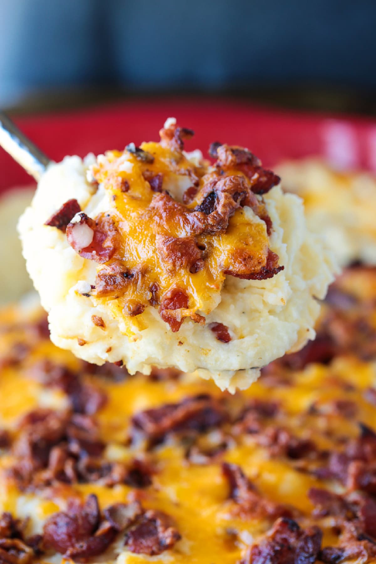 This Loaded Mashed Potato Casserole is so hearty and delicious. A make ahead potato side dish that makes party planning and holidays so easy! loaded mashed potato casserole on serving spoon