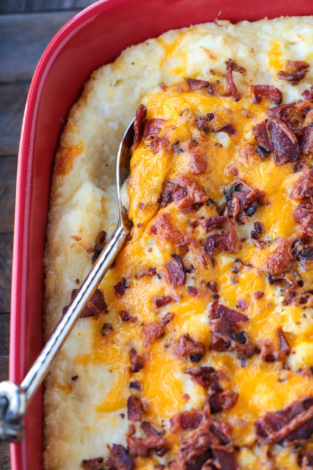 This Loaded Mashed Potato Casserole is so hearty and delicious. A make ahead potato side dish that makes party planning and holidays so easy! loaded mashed potato casserole with serving spoon