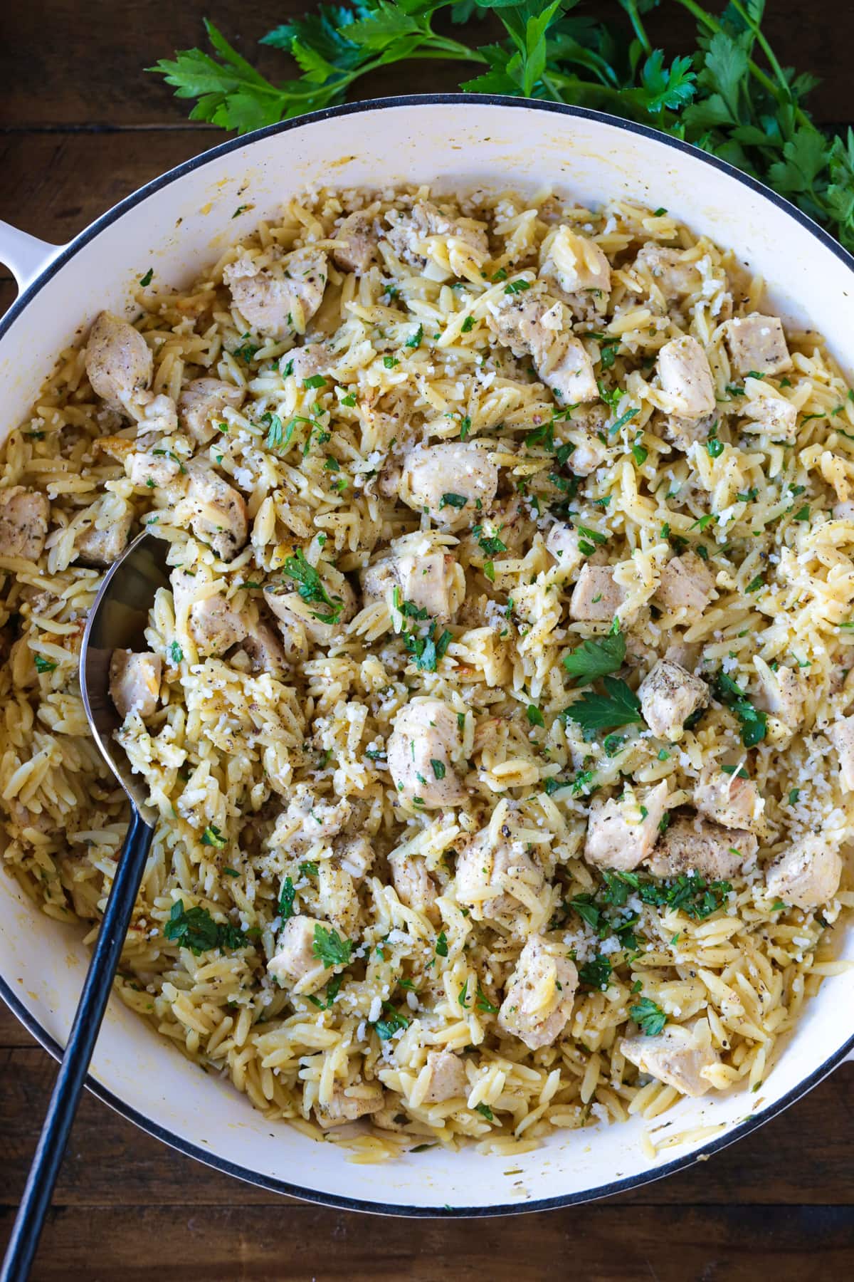 orzo and chicken in white skillet with spoon