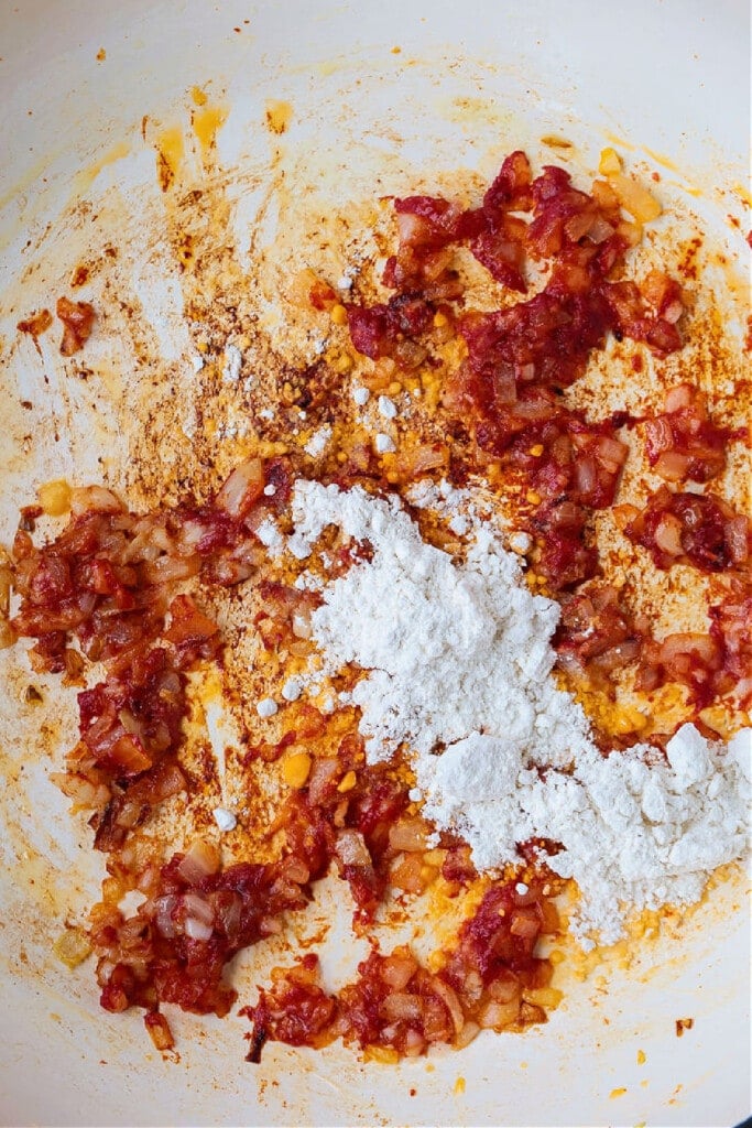 Pappardelle with Champagne Cream Sauce is perfect for the holidays! Pappardelle pasta tossed in a tomato cream sauce with real champagne! onions, tomato paste and flour in the bottom of a pot