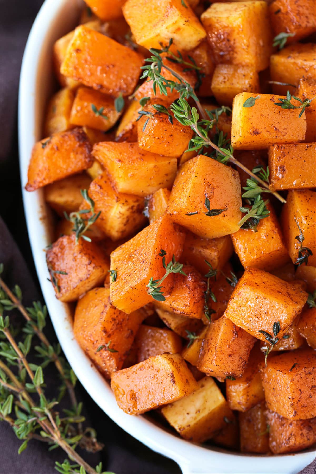 This simple Roasted Butternut Squash is so full of flavor. An easy side dish that goes with just about any dinner, especially a holiday meal! cubes of roasted butternut squash in white dish from top