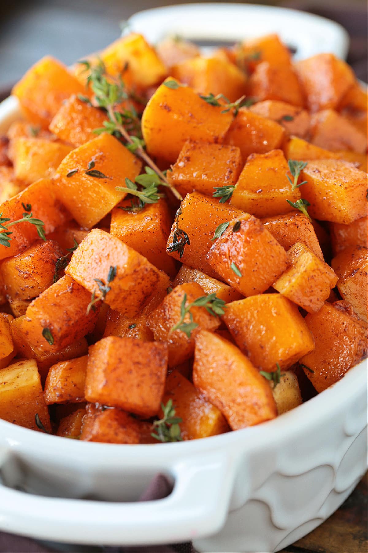 This simple Roasted Butternut Squash is so full of flavor. An easy side dish that goes with just about any dinner, especially a holiday meal! butternut squash cubes in baking dish