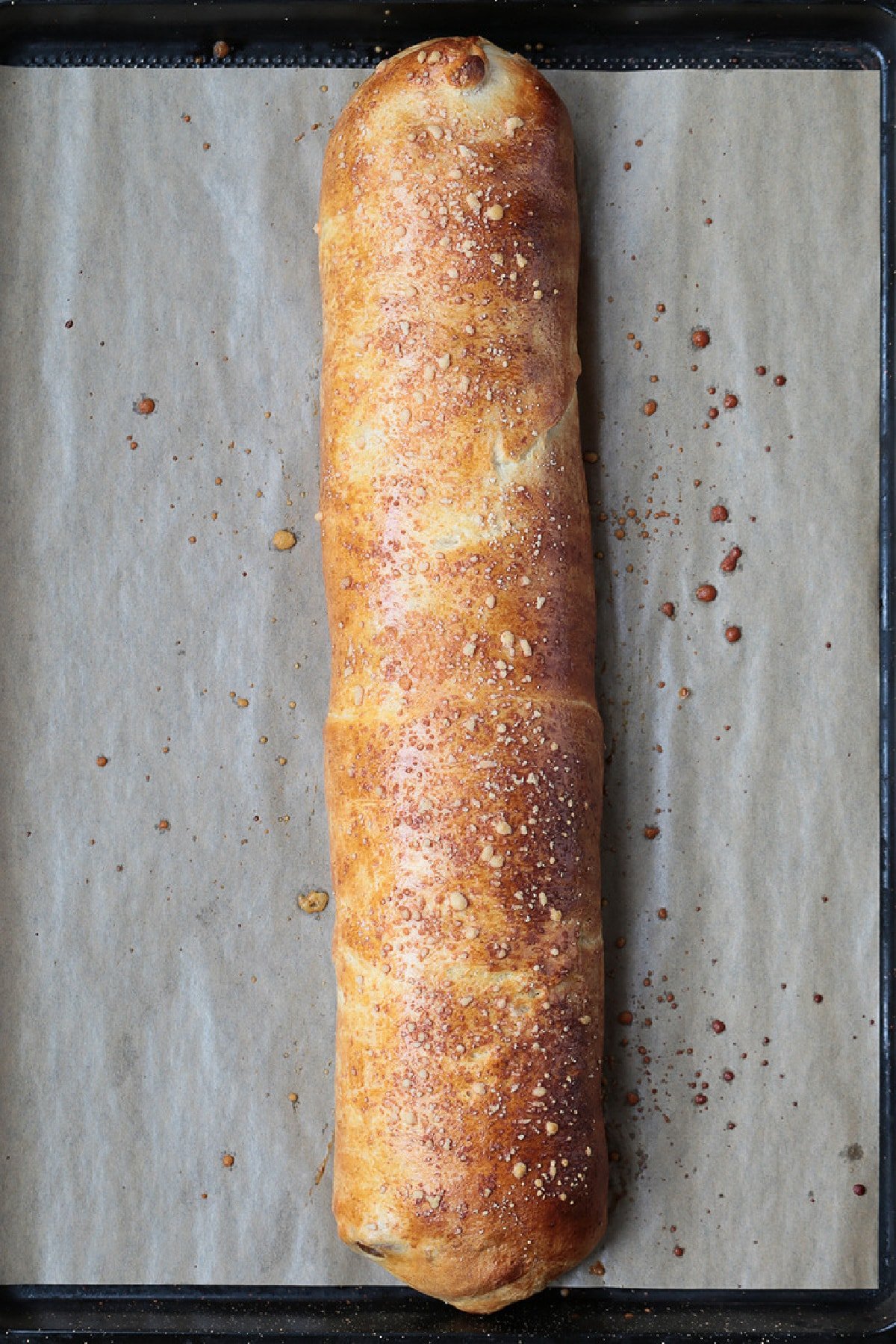 Our Sausage Bread recipe is packed full of sausage and cheese. Slice and serve for appetizers or for a fun dinner night instead of pizza. cooked sausage bread on baking sheet