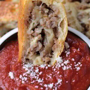 slice of sausage bread dipped into marinara sauce