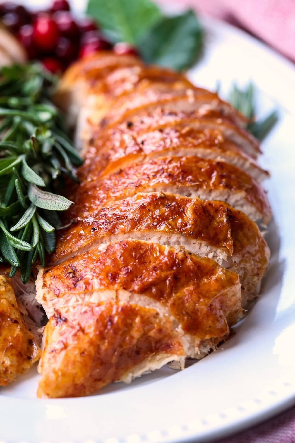 Our Simple Roast Turkey recipe is moist and juicy every time! Don't let a whole turkey scare you, our recipe will make you look like a pro! sliced turkey breast on platter with rosemary