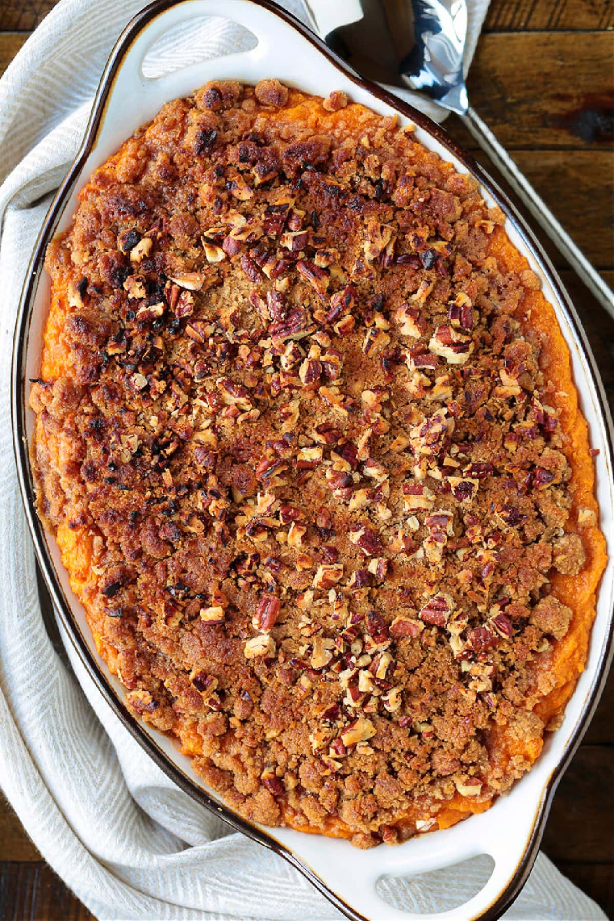 Our Sweet Potato Souffle is light and fluffy with a sweet, nutty streusel topping! A make ahead side dish for all of your holiday dinners! baking dish with sweet potato souffle recipe from the top